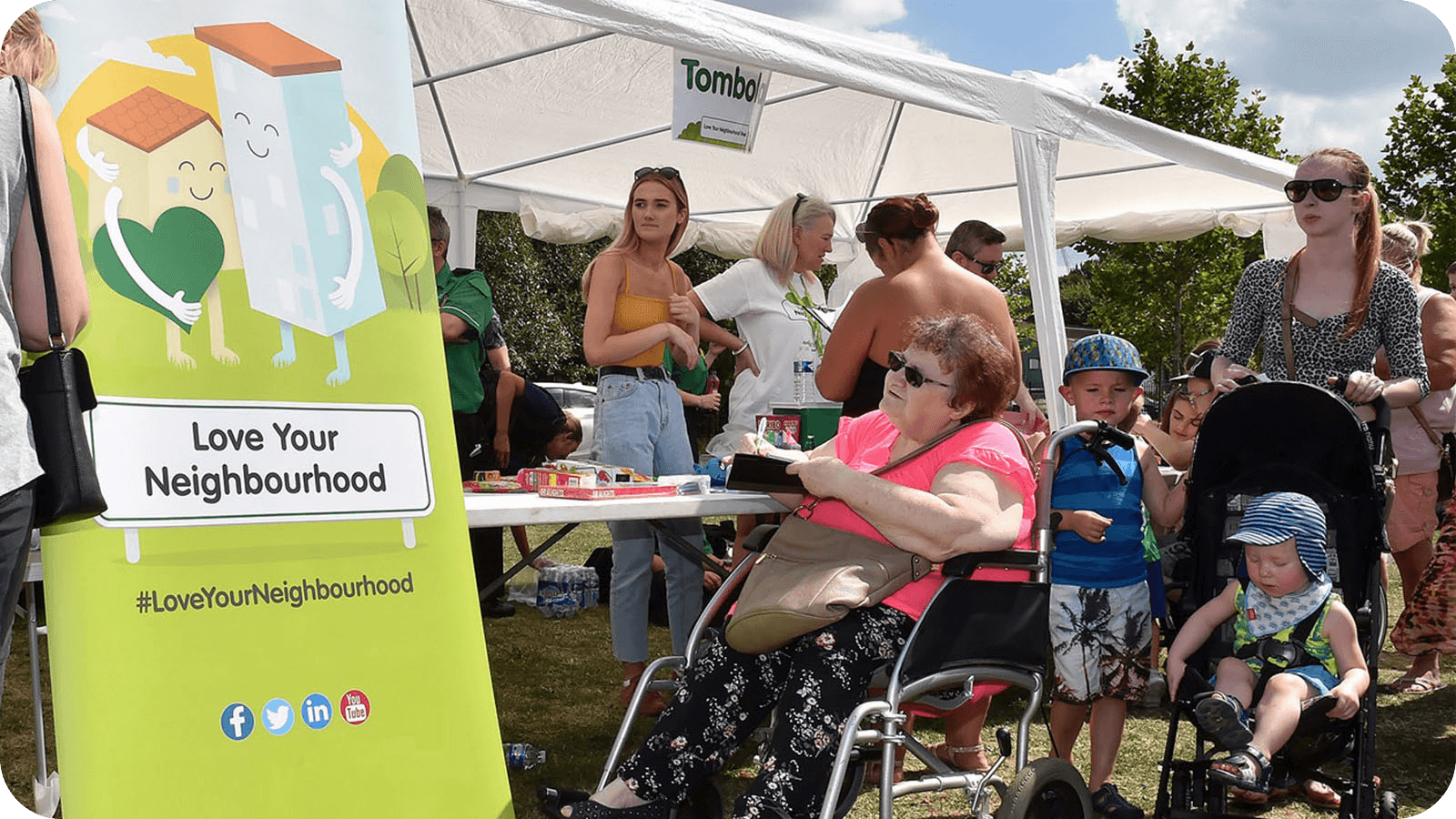 A lady in a wheelchair, and families at a community event